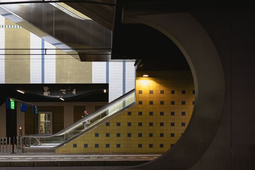 A subway station featuring a modern escalator and artistic wall designs, showcasing urban infrastructure beauty.