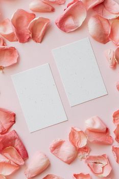 粉红色背景上，玫瑰花瓣与空白卡片优雅排列，非常适合浪漫场合