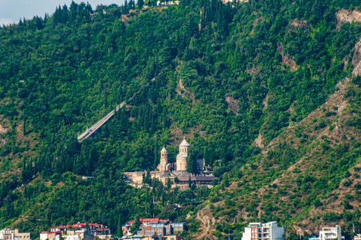 Aerial view of a historic Georgian monastery nestled in lush green hills.