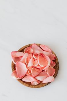 精致的粉红色玫瑰花瓣在圆形木盘上排列，非常适合装饰或美容主题