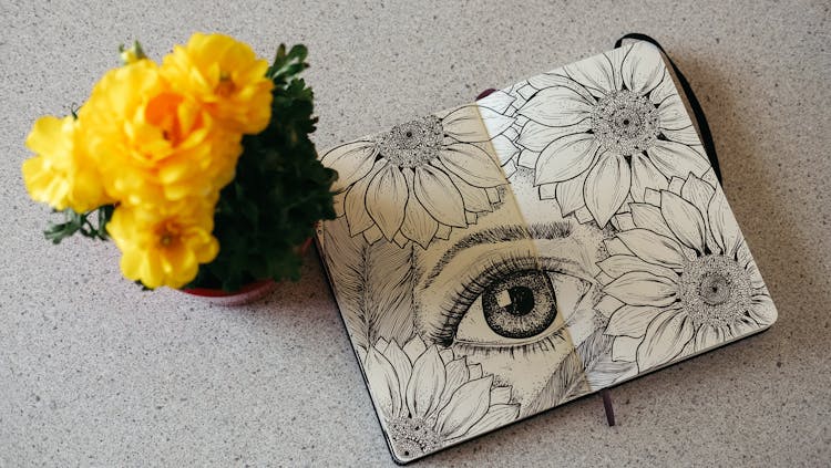 Ink Drawing Of Eye And Flowers Next To Bouquet Of Yellow Flowers