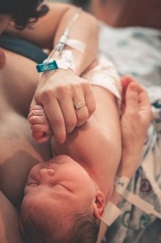 新生婴儿紧握母亲手的特写，象征着爱与联系