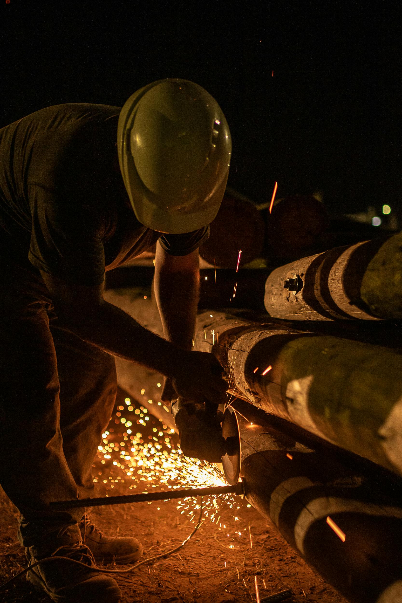 Construction worker cutting metal and creating sparks