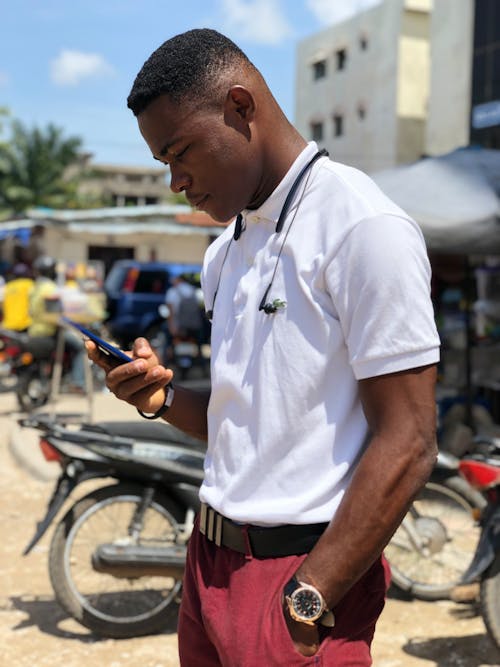 Free Man in a White Shirt Using His Smartphone Stock Photo