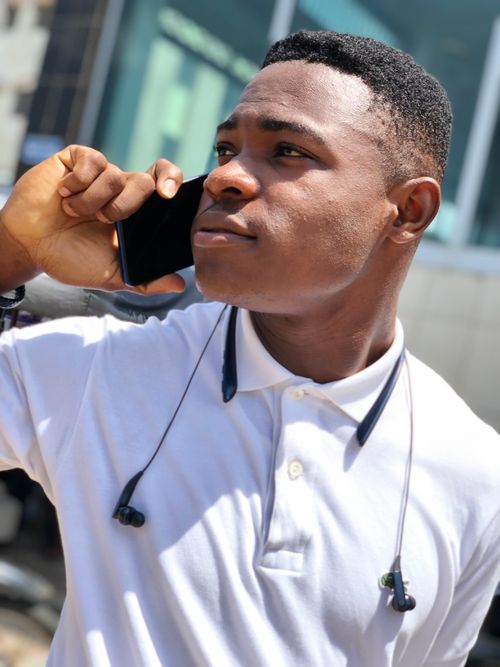 Free Confident young man having a phone conversation outdoors in Ikeja, Nigeria. Stock Photo