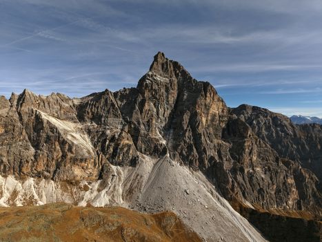 A breathtaking aerial shot of a rugged Dolomites peak set against an autumn sky.