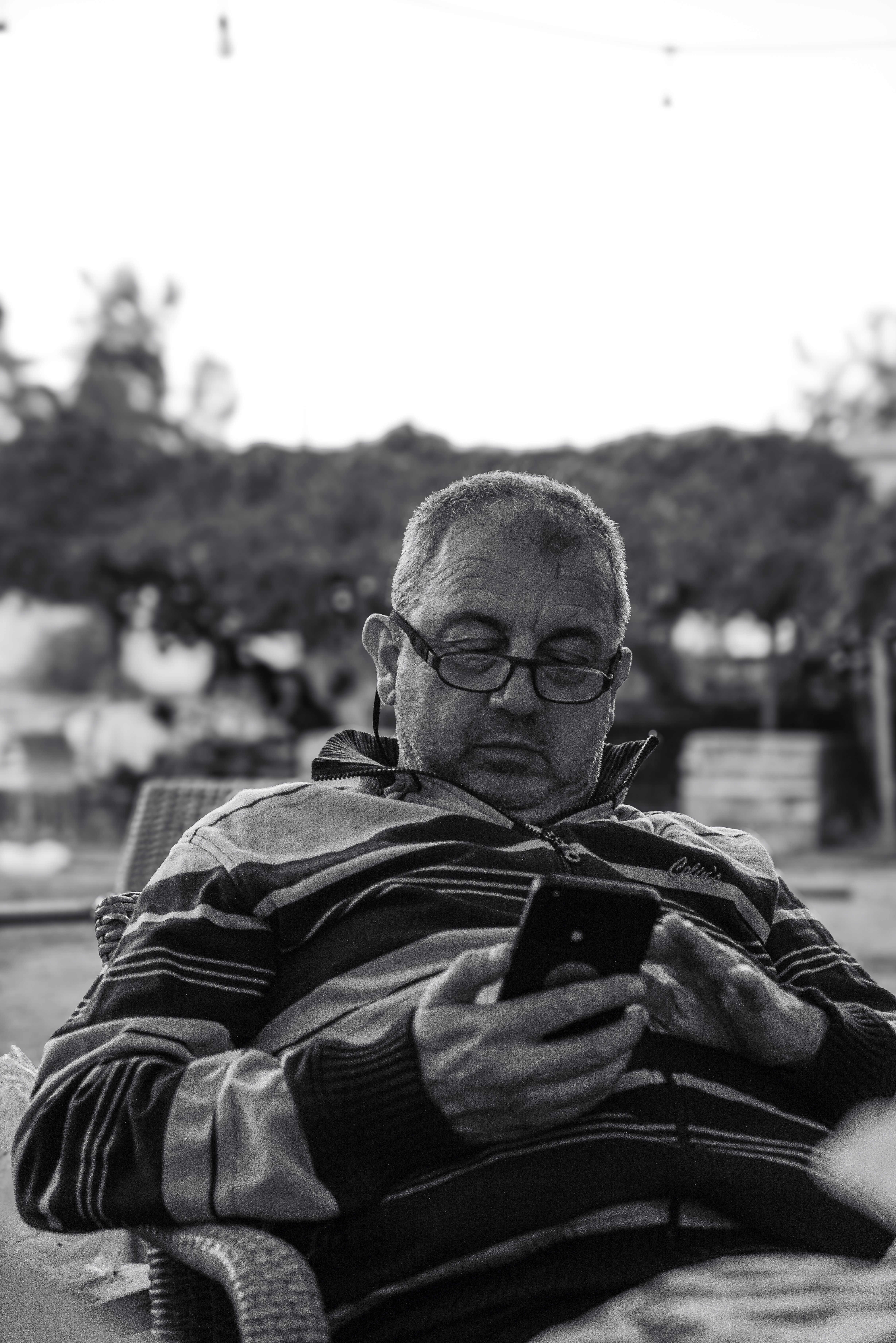 Candid Black and White Portrait of Man Using Smartphone · Free Stock Photo
