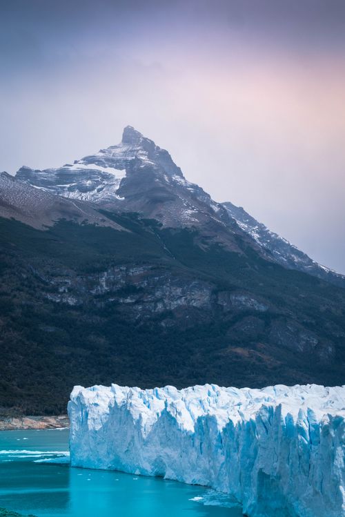 Free Breathtaking scene of the Perito Moreno Glacier with a majestic Patagonian mountain backdrop. Stock Photo