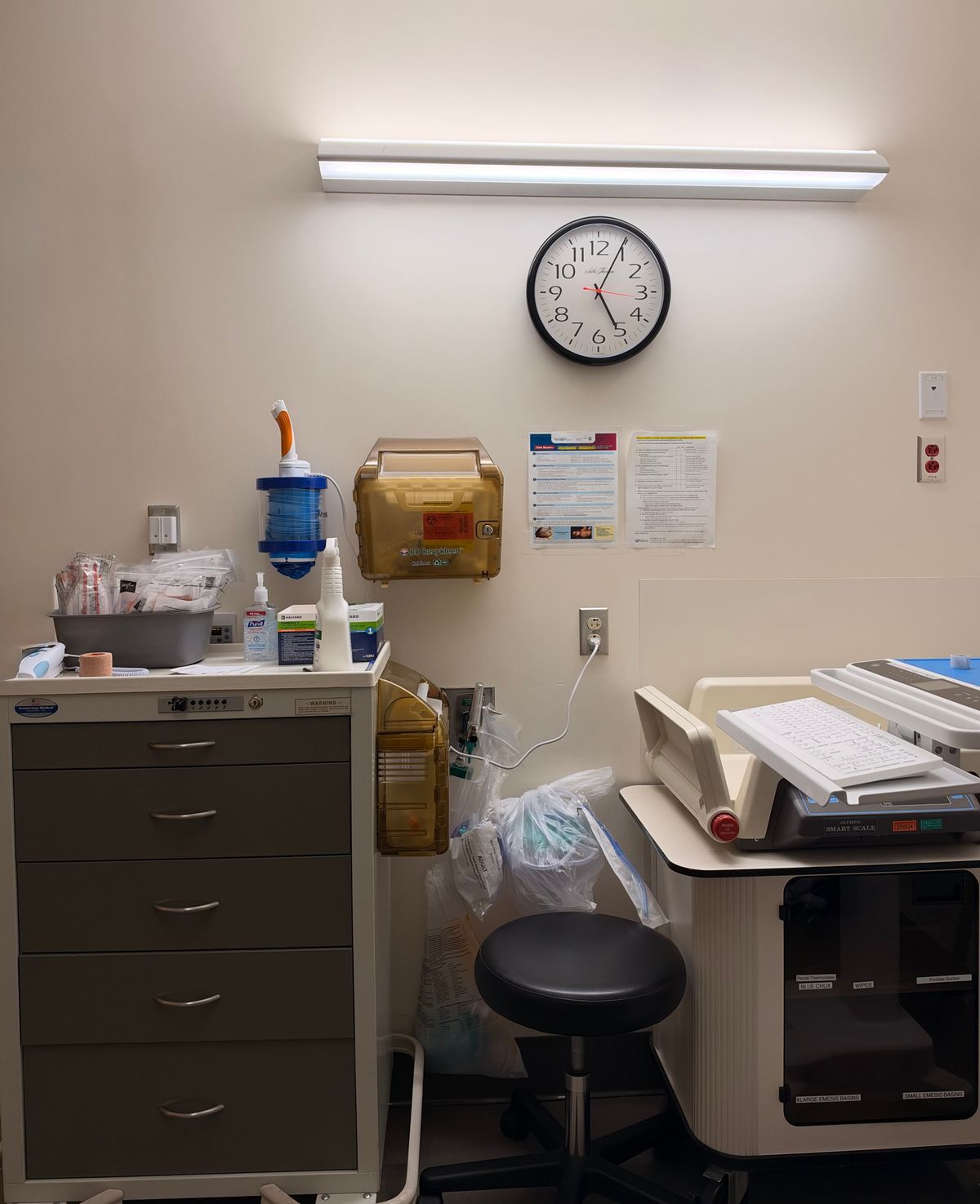 hospital emergency equipment beside a wall clock