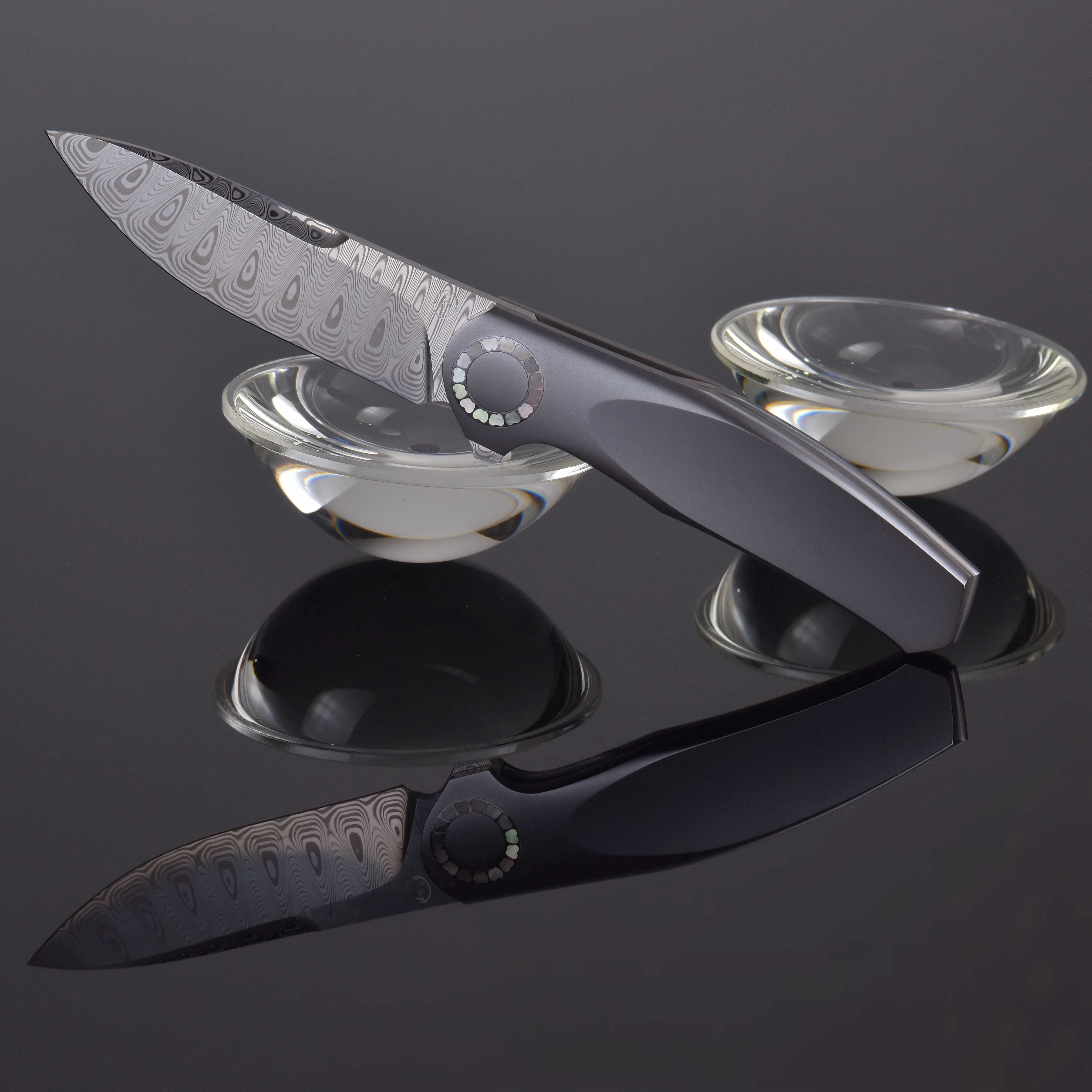 Elegant Damascus Steel Knife on Reflective Surface · Free Stock Photo