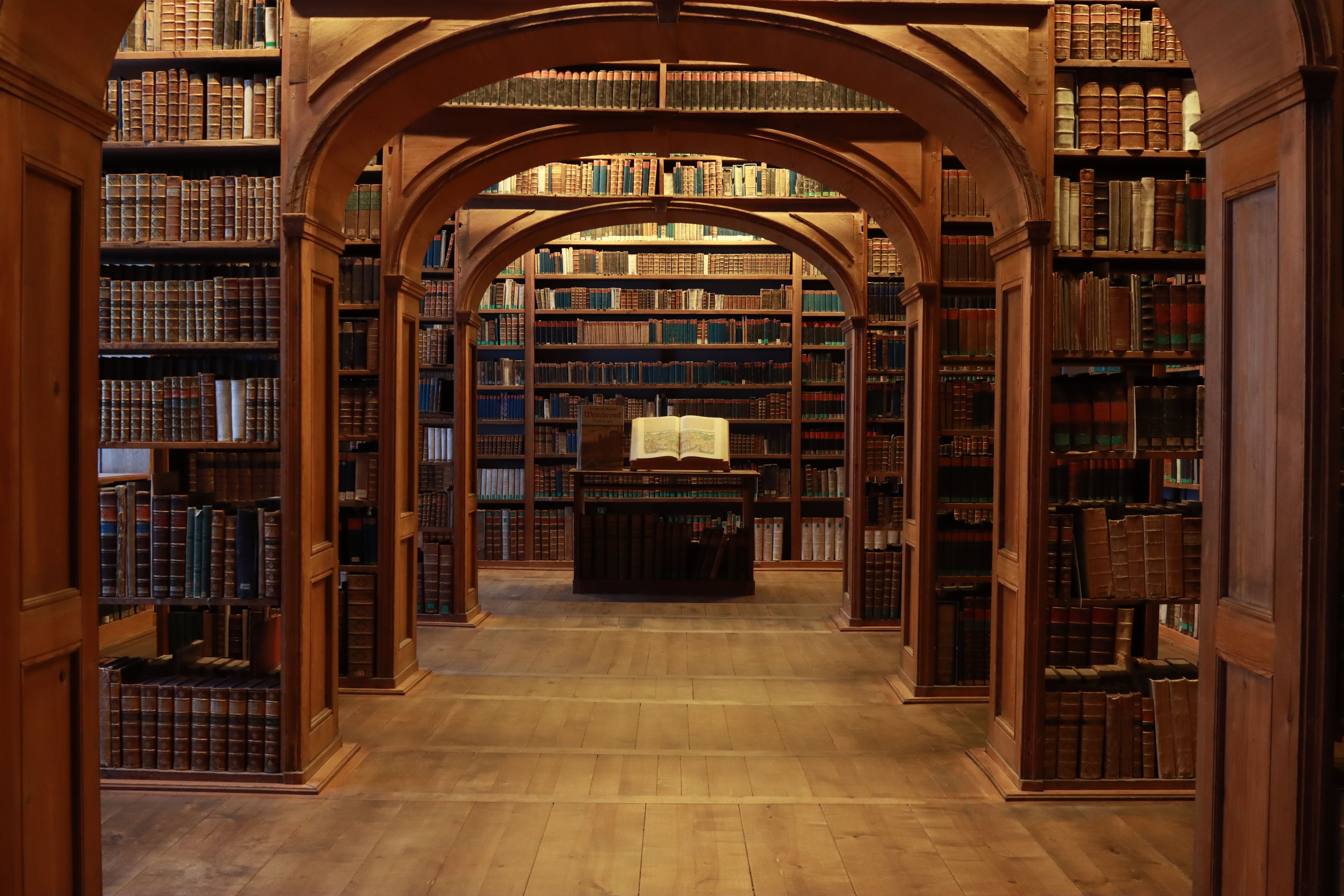 Historic Library with Wooden Arches and Bookshelves · Free Stock Photo