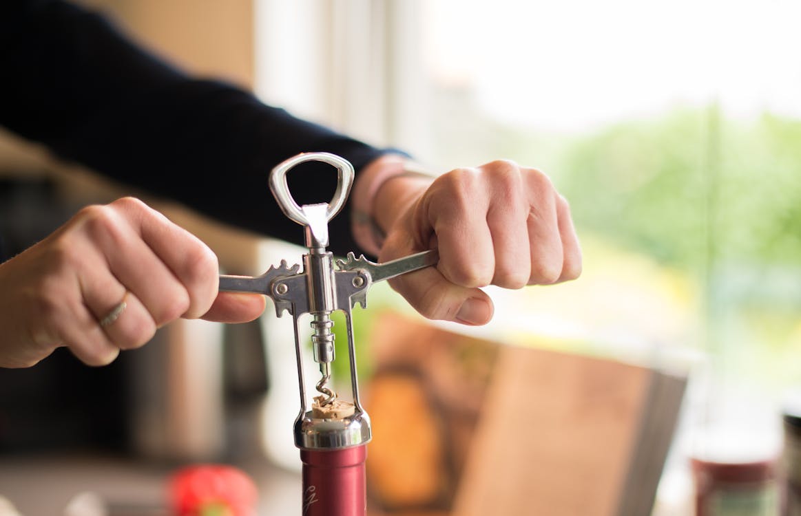Person Holding Cork Opener