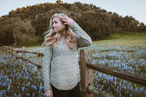 Free Woman in Gray Sweater Standing on Green Grass Field Stock Photo