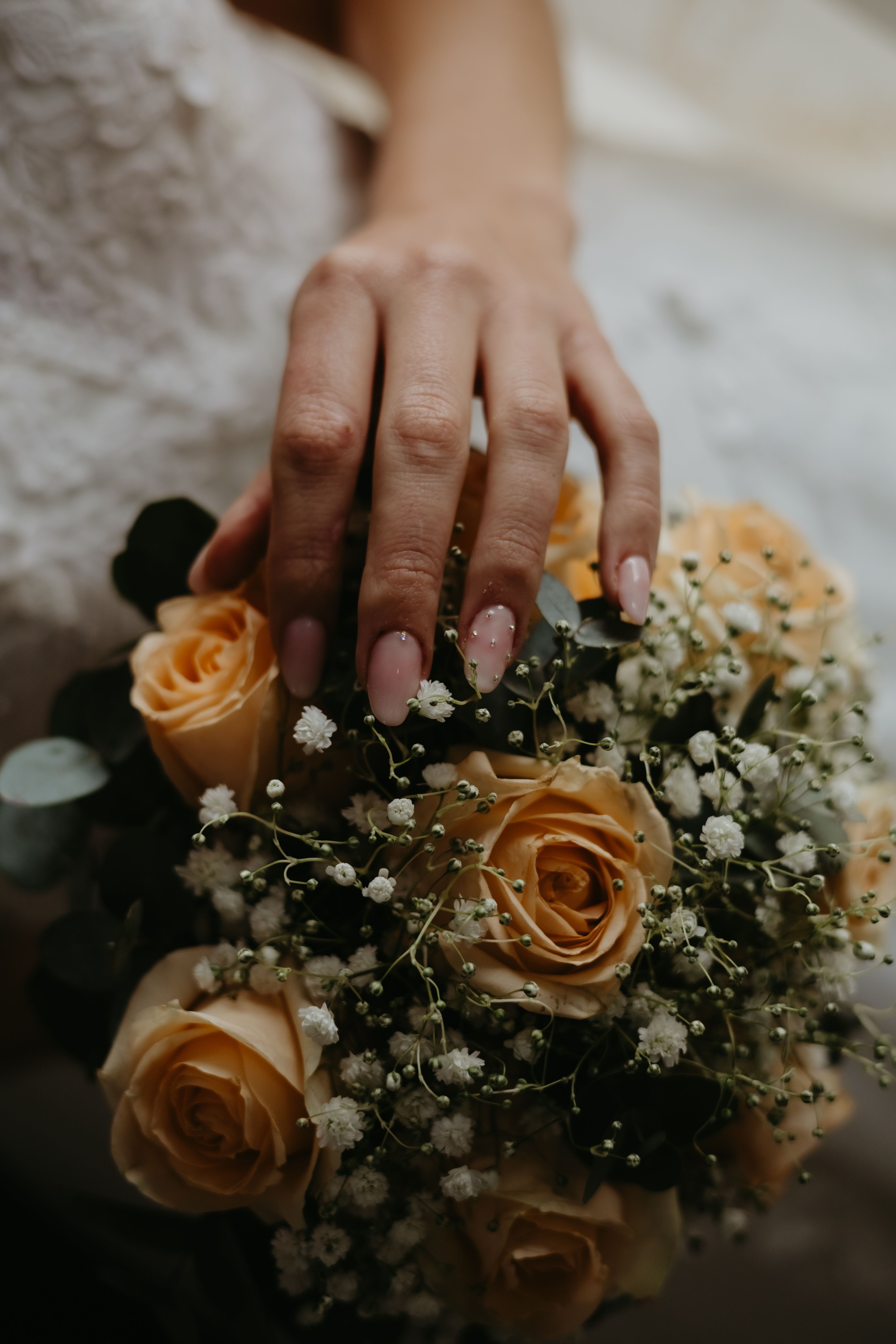 Elegant Bridal Hand with Rose Bouquet · Free Stock Photo