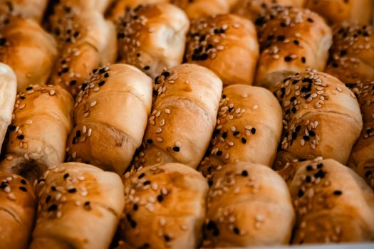Delicious golden croissants topped with sesame seeds, perfect for breakfast or brunch.