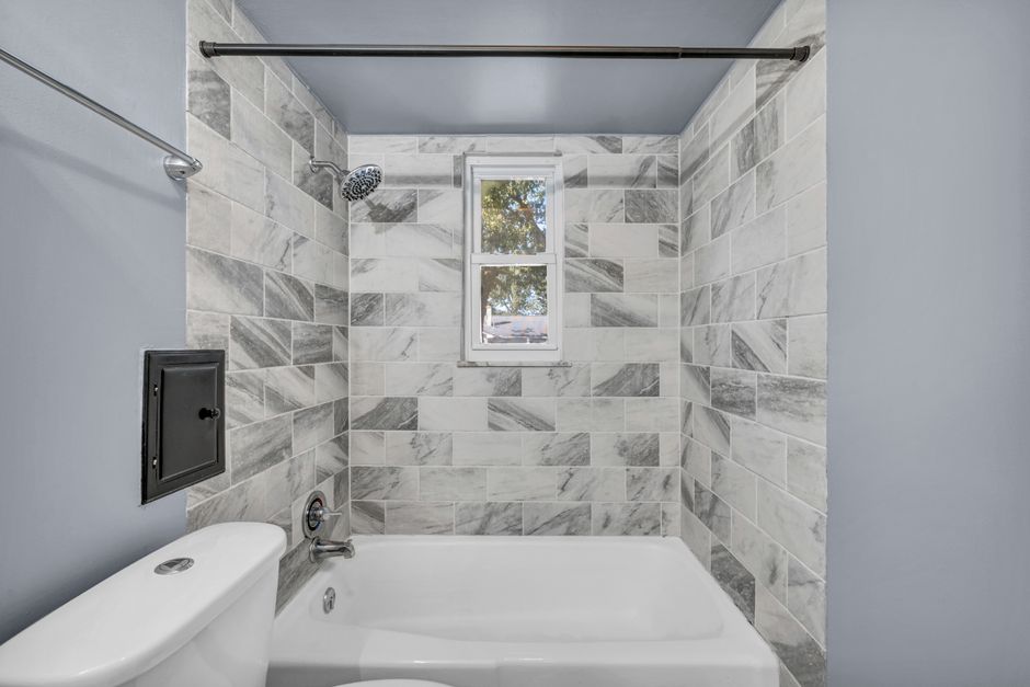 Contemporary bathroom featuring elegant marble tiles and a pristine bathtub.