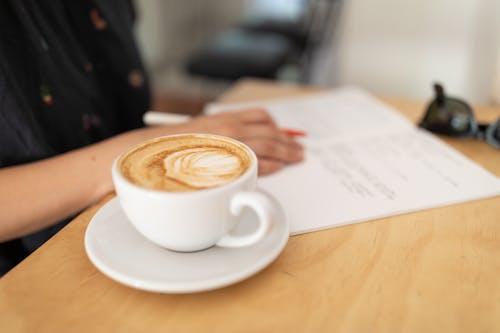 Woman Working with a Cup of Coffee on the Table