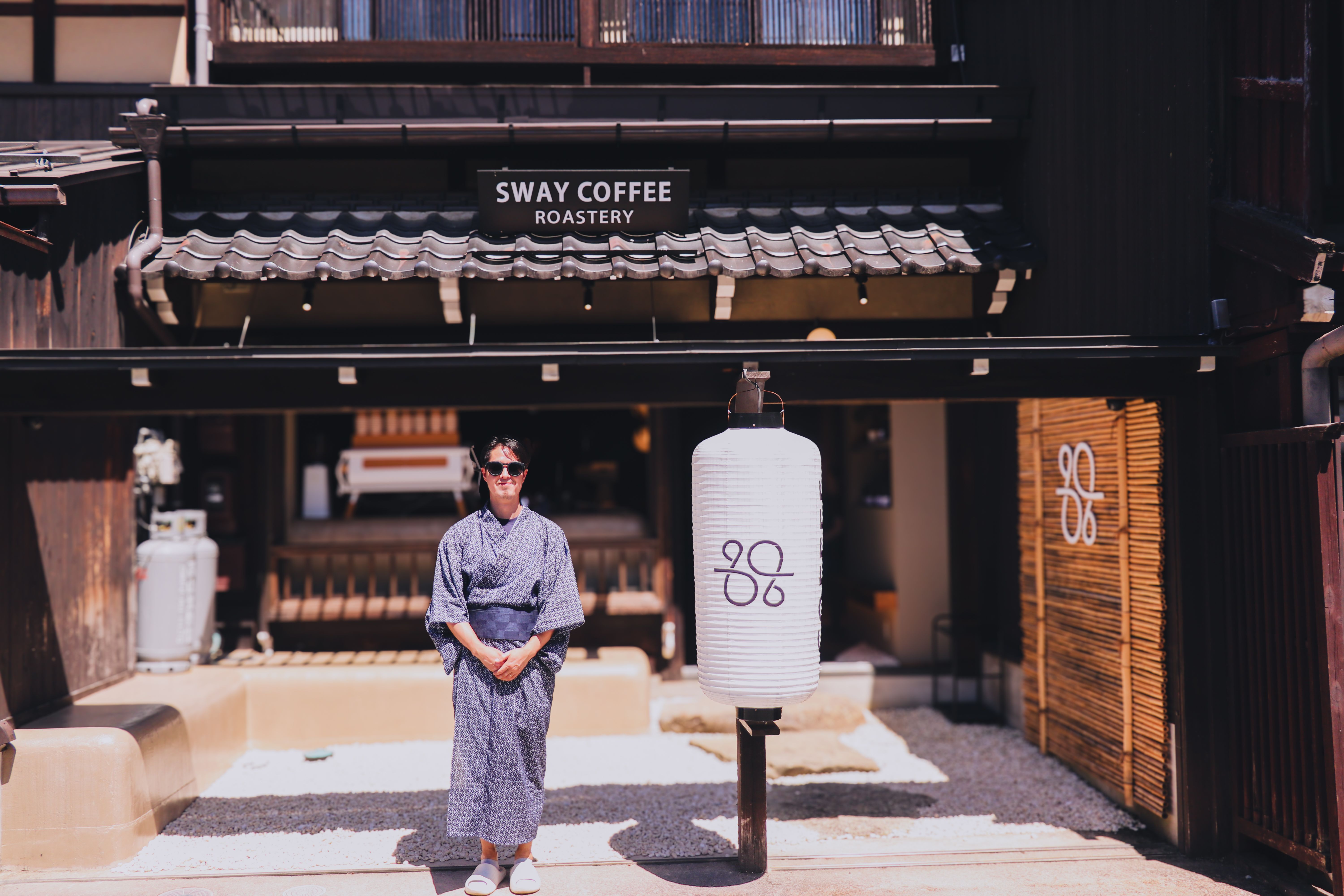 A visitor stands in front of a traditional Japanese coffee shop named Sway Coffee Roastery.