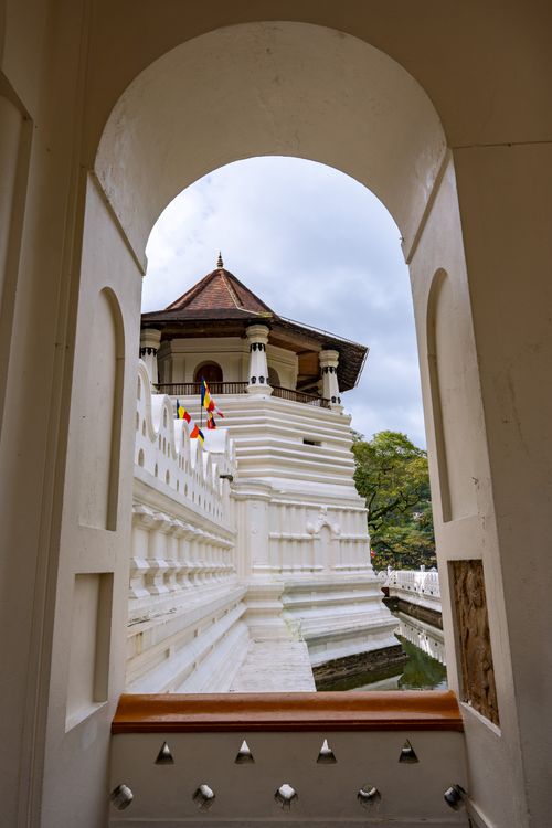 Free View of the Temple of the Tooth in Kandy framed by an archway. Stock Photo