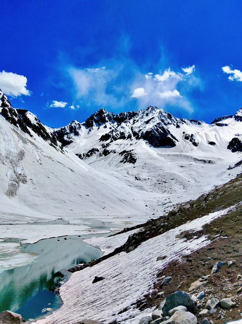 Free Breathtaking view of snow-covered mountains and a serene lake in Khyber Pakhtunkhwa, Pakistan. Stock Photo