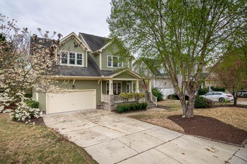 Free A picturesque suburban home with a lush front yard, driveway, and trees. Stock Photo