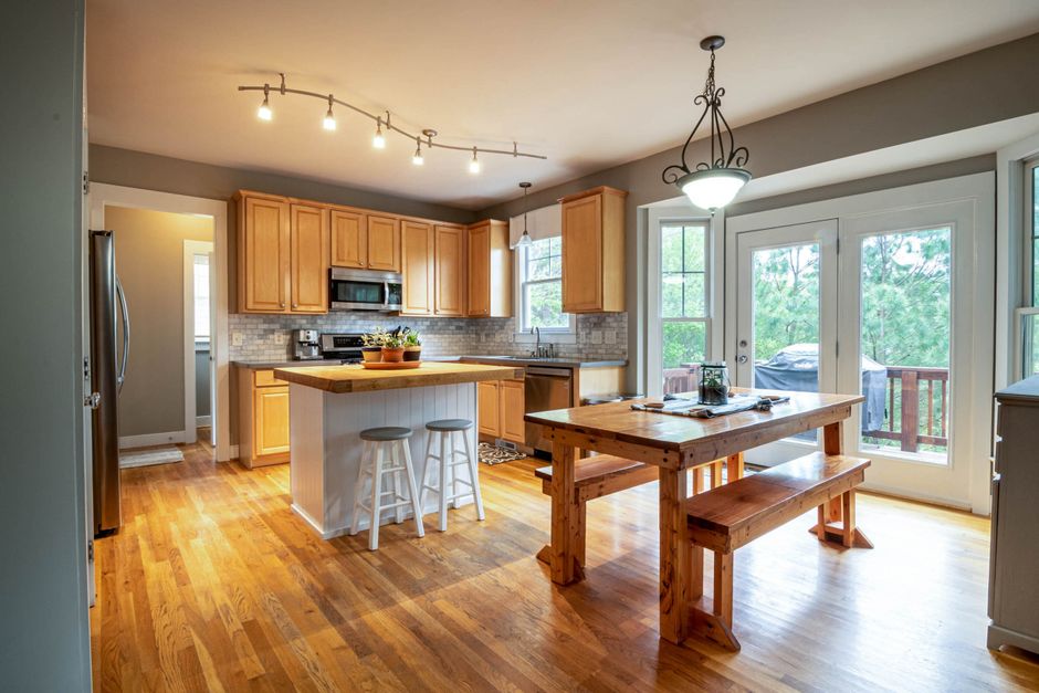 Bright and cozy kitchen interior with wooden furniture and garden view.