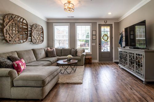 Free Spacious living room featuring a large sofa, wooden floor, and stylish decor. Stock Photo