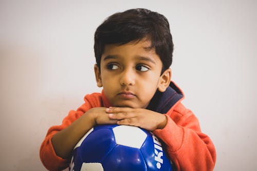 Free Young Boy Holding a Football Stock Photo