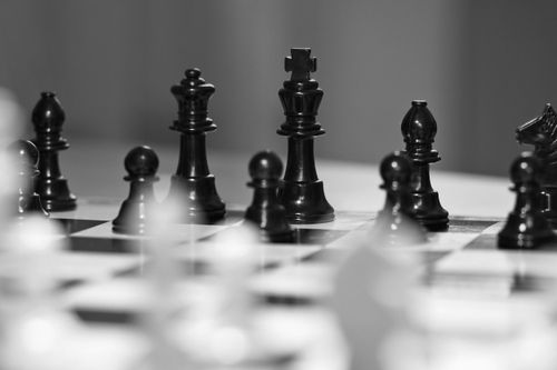Free Artistic black and white close-up of a chessboard with focus on the king piece, symbolizing strategic thinking. Stock Photo