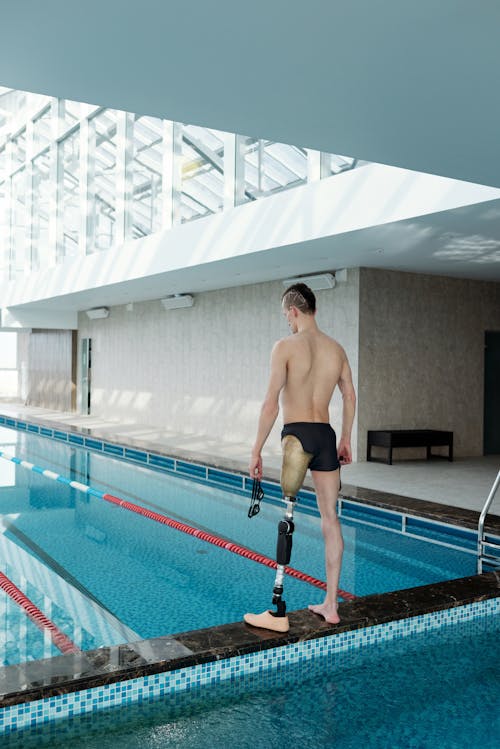 Man with Prosthetic Leg Standing by Swimming Pool