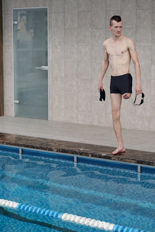 無料 スイミングプールの横に立っている男 写真素材