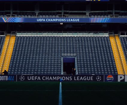 Empty stadium seating with UEFA Champions League signage and minimal crowd.