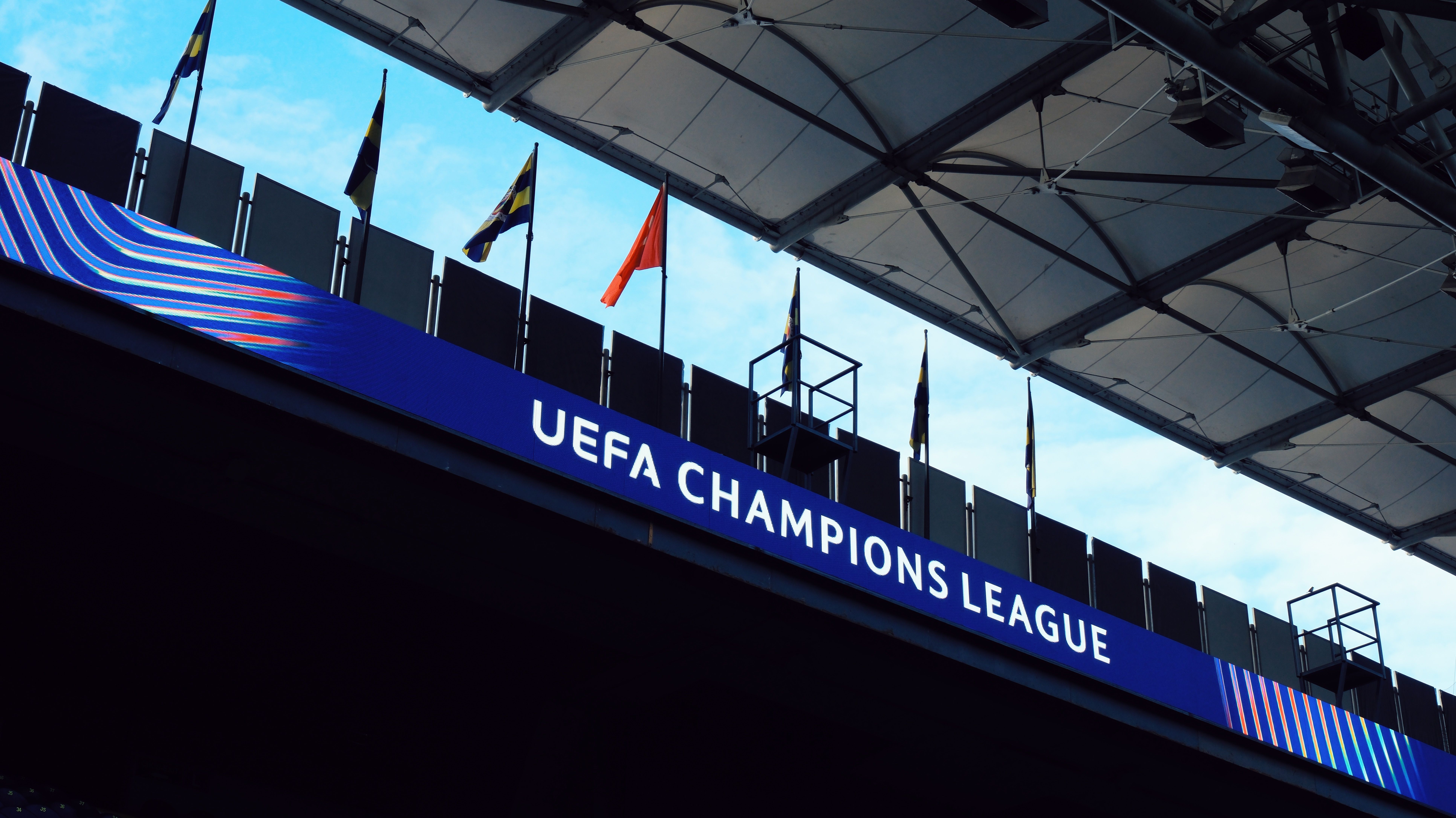 UEFA Champions League signage inside a stadium with flags and architectural details.