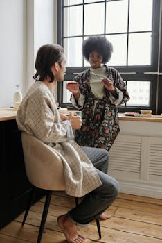 A couple enjoying a relaxed morning chat and coffee in a cozy, sunlit room.