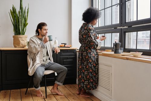 Free A couple enjoying a relaxed morning coffee together in their cozy kitchen. Stock Photo