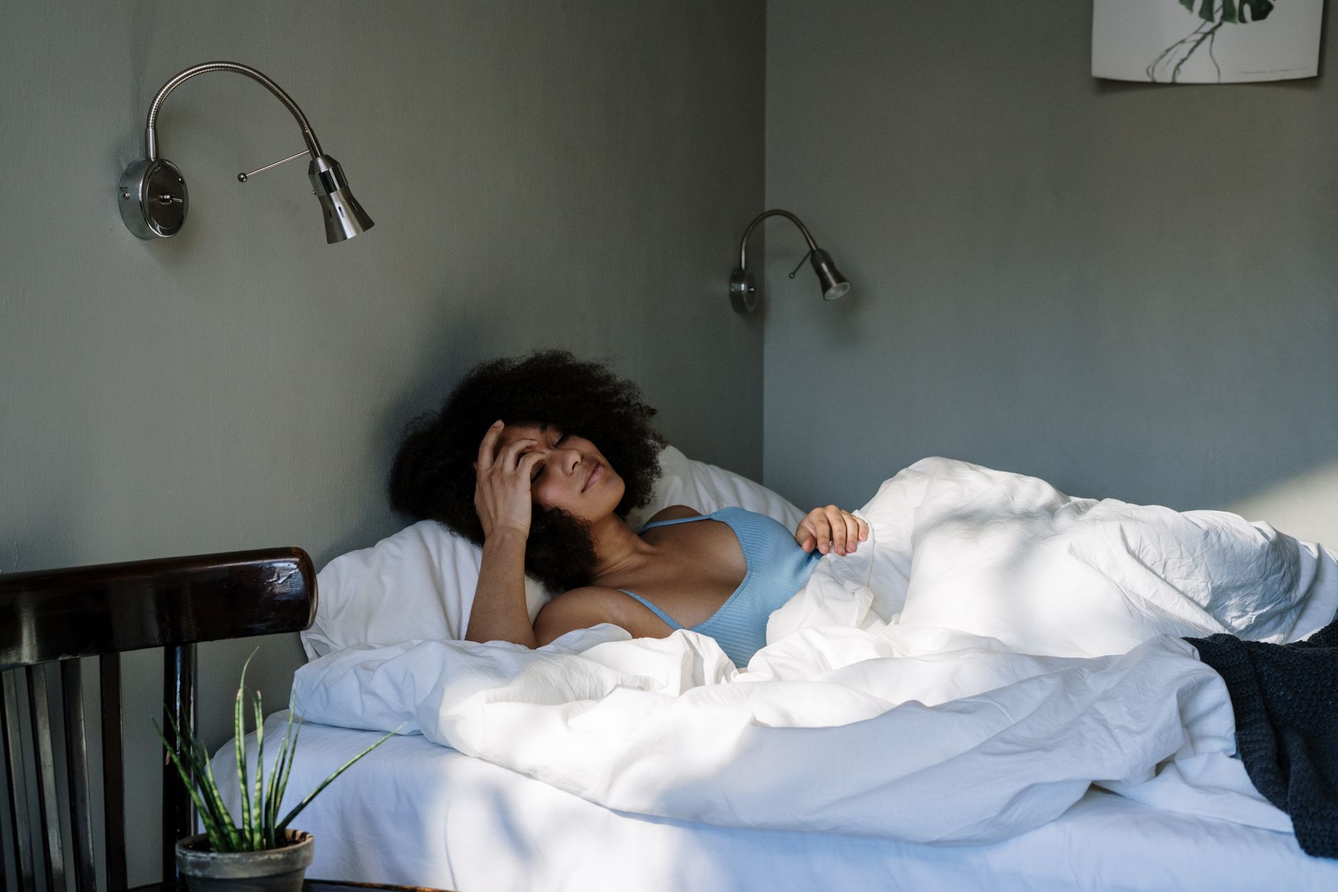 A woman resting in bed during a serene morning, surrounded by cozy home ambience.