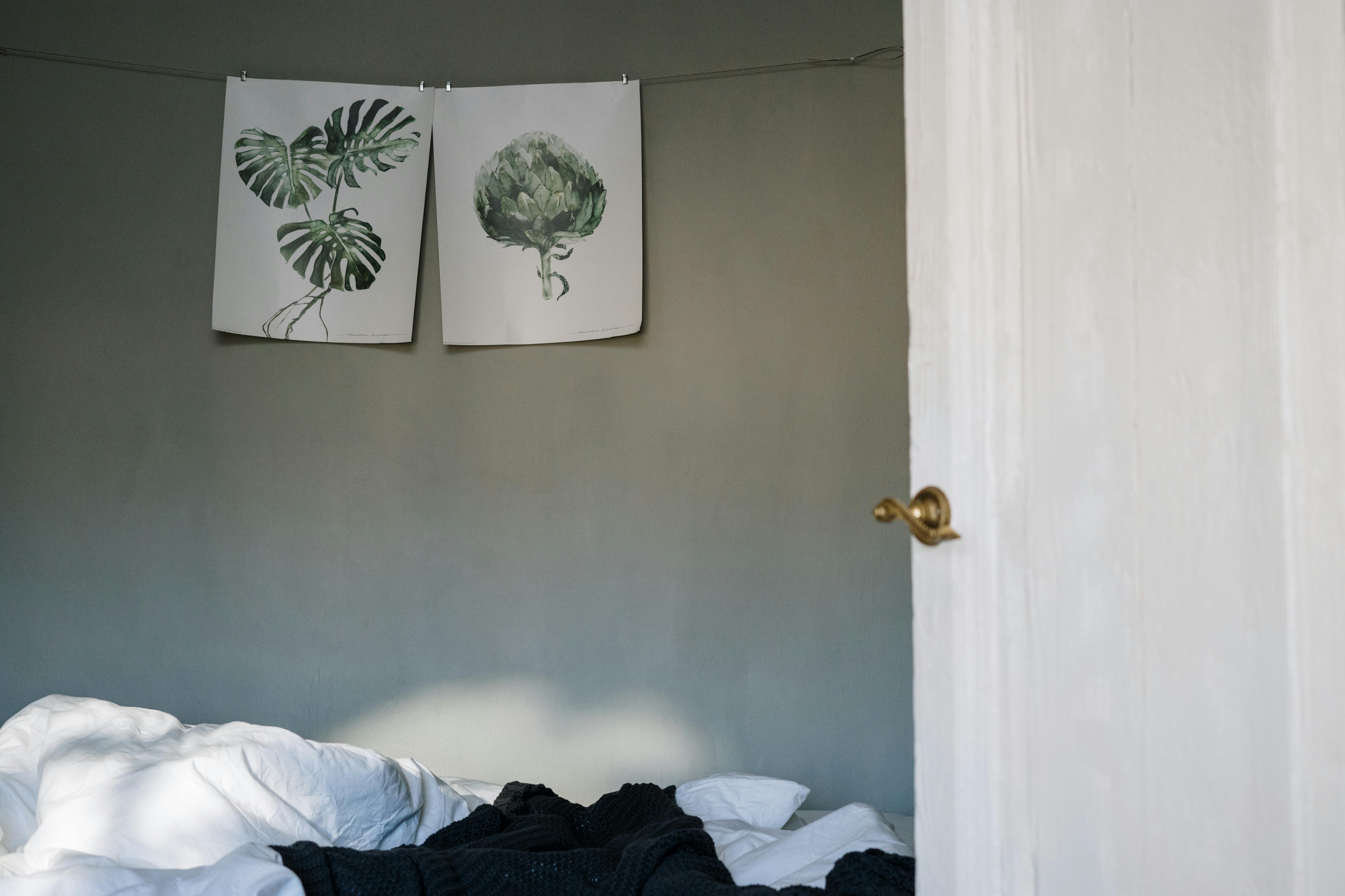 Inviting bedroom featuring botanical art and soft linen bedding, perfect for a tranquil morning.