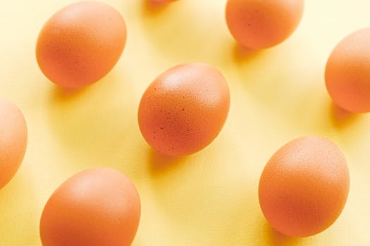 Brown eggs arranged on a vibrant yellow background in a minimalist style.