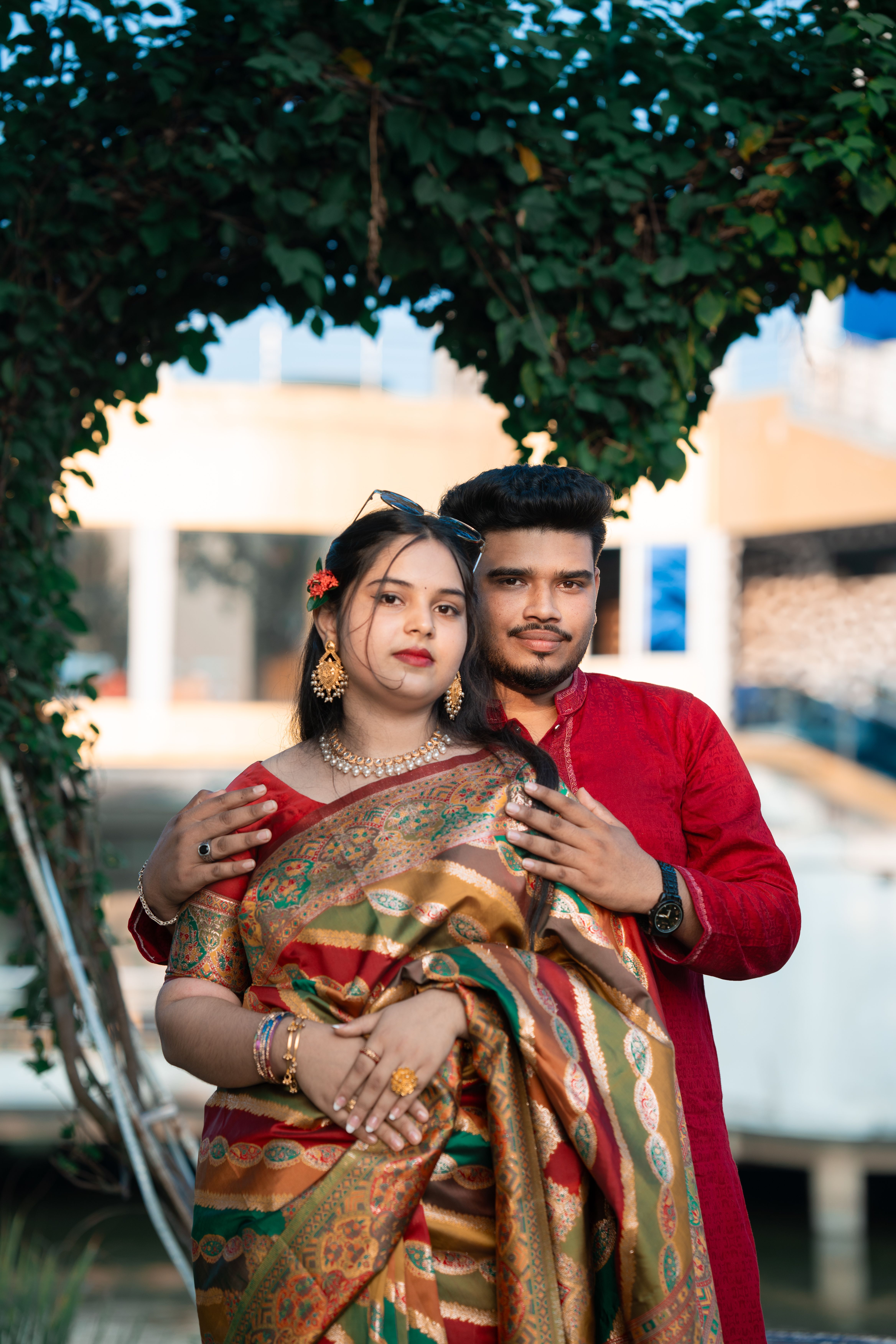 Traditional Couple Pose Under Green Arch · Free Stock Photo