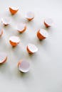 在浅色背景上，破碎的蛋壳以极简主义风格排列，展现了简单与脆弱