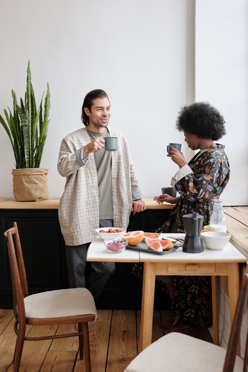 Free A cheerful couple enjoying morning coffee together with a healthy breakfast and cozy atmosphere. Stock Photo