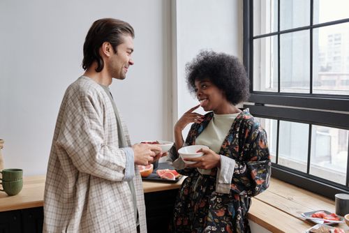 Free Multiracial couple enjoying breakfast together, expressing happiness and love. Stock Photo