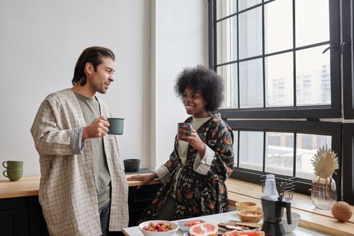 Free Happy couple enjoying morning coffee together in cozy kitchen setting. Stock Photo