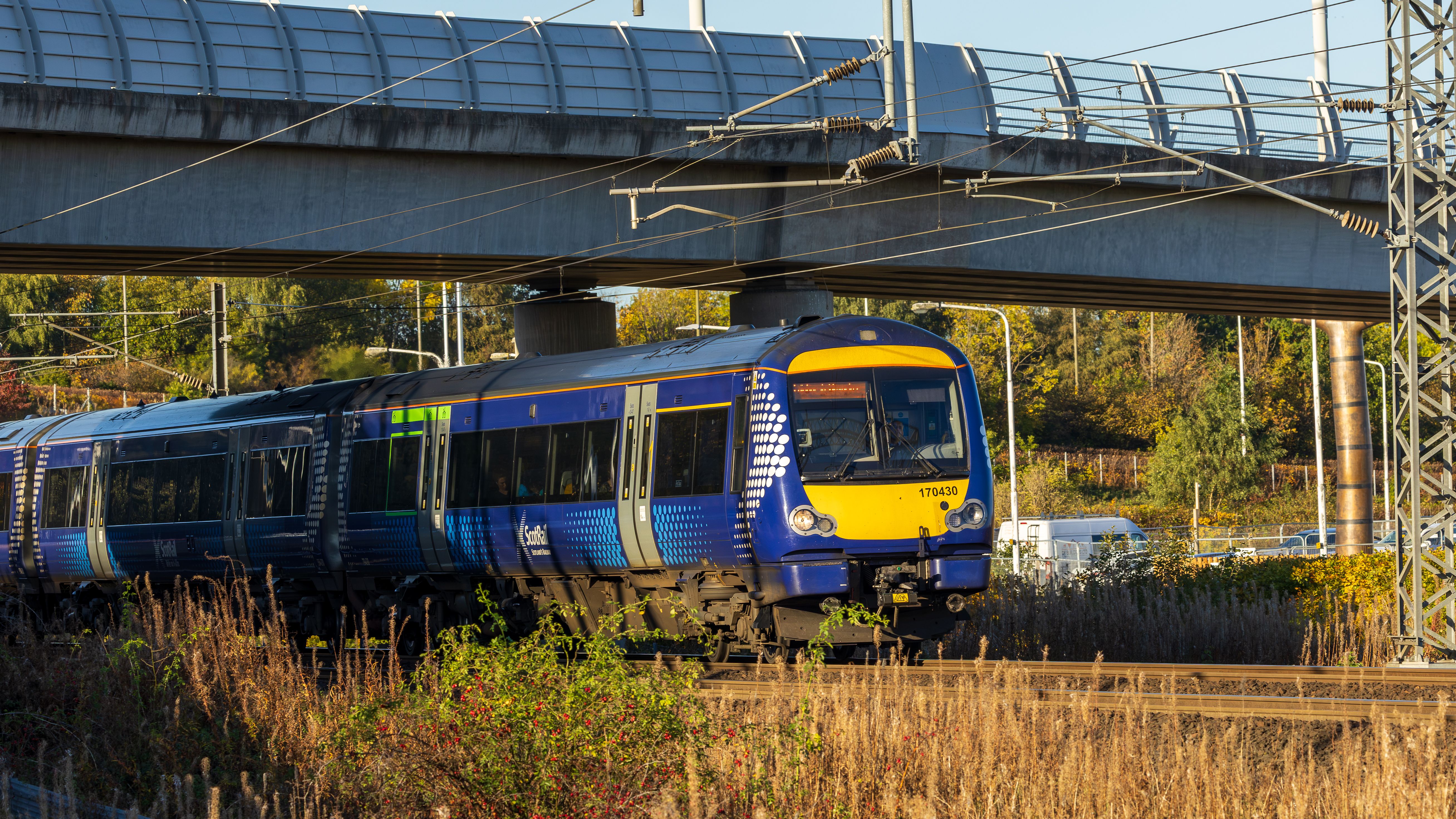 Scottish Train Passing Under Bridge in Autumn · Free Stock Photo