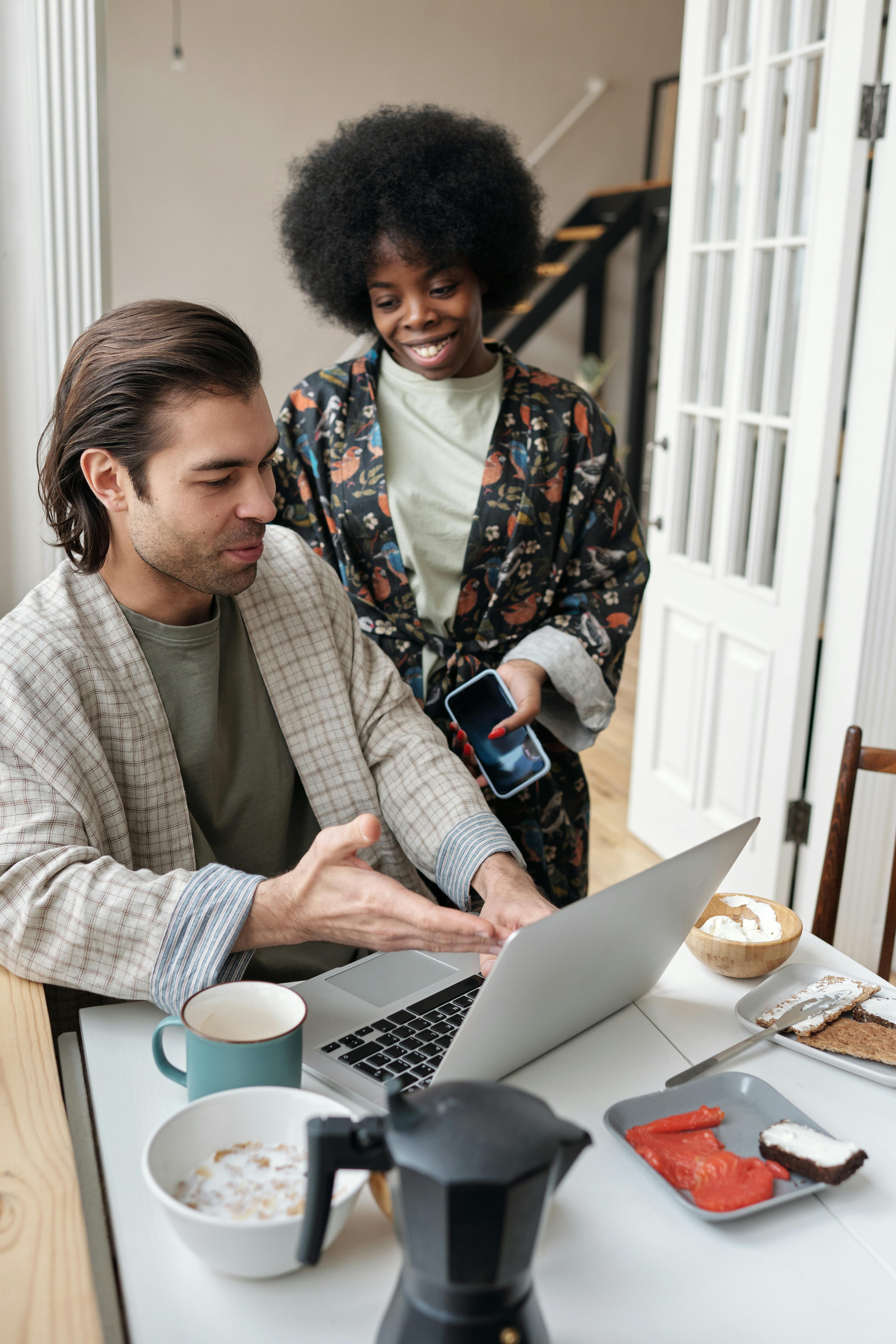 man using laptop while having breakfast