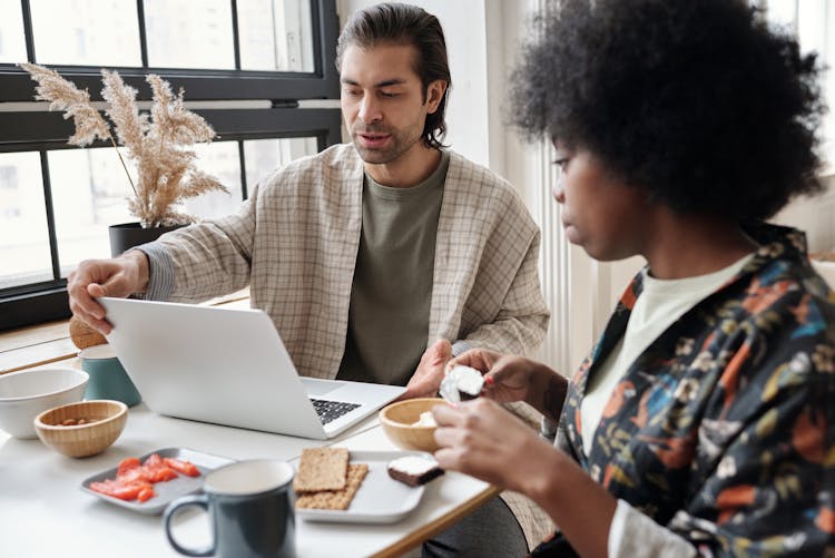 Man Using Laptop While Having Breakfast