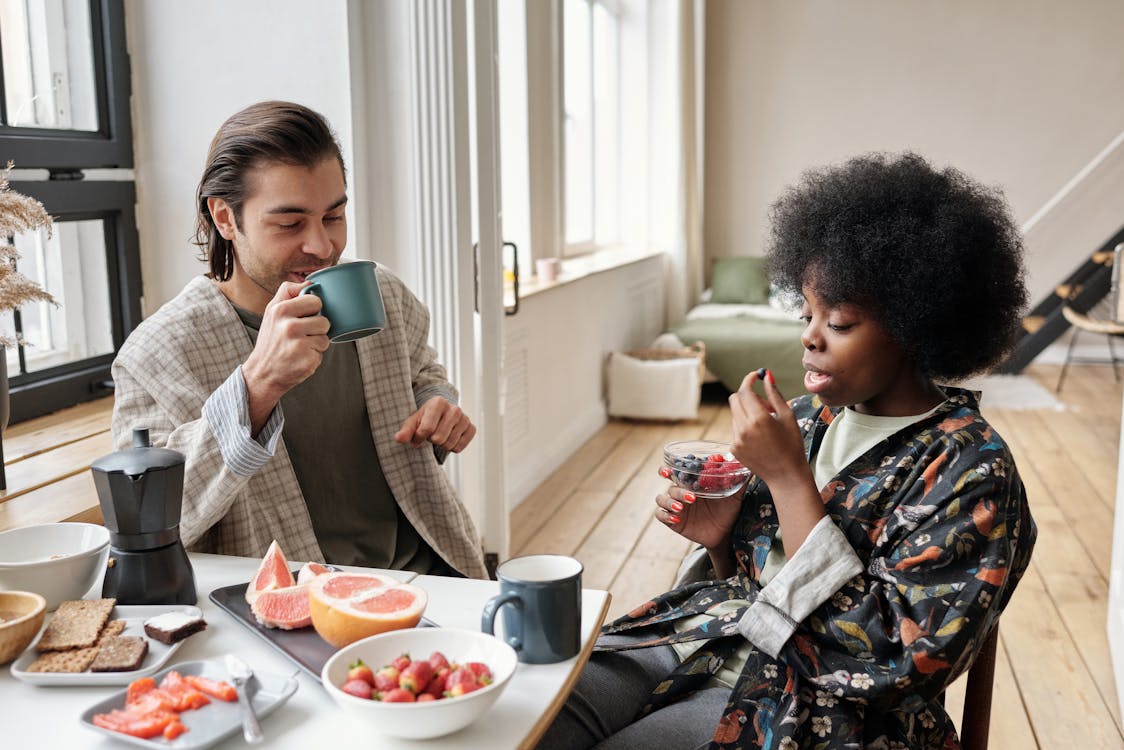 Man And Woman Having Breakfast with coffee and healthy fruits