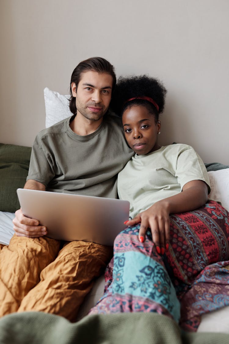 Young Couple Taking Selfie In Bed