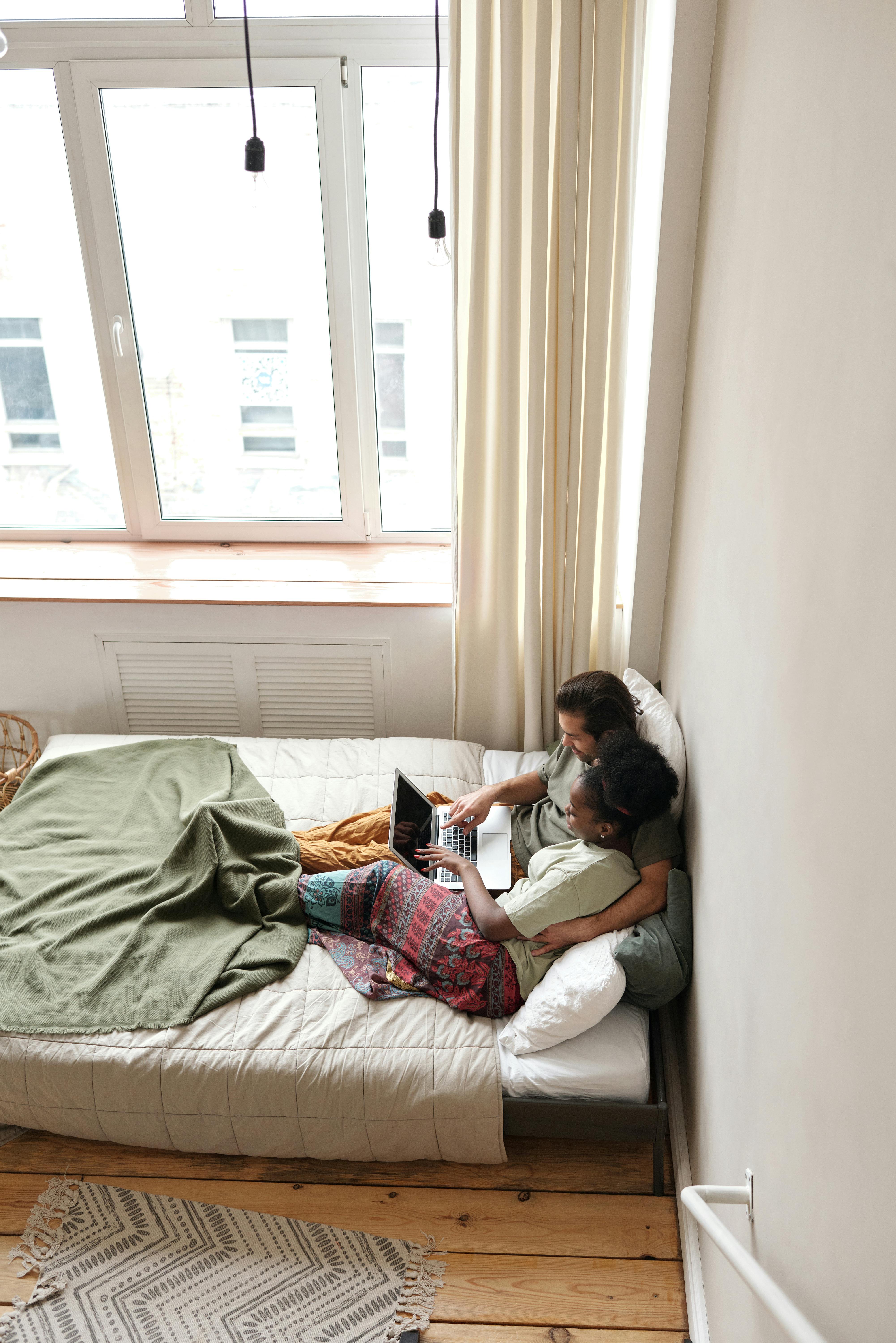 couple in bed with a laptop