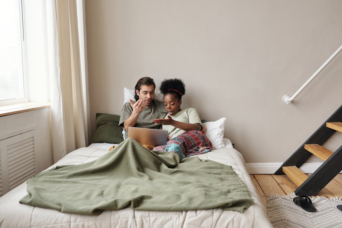 Couple in Bed With a Laptop Arguing